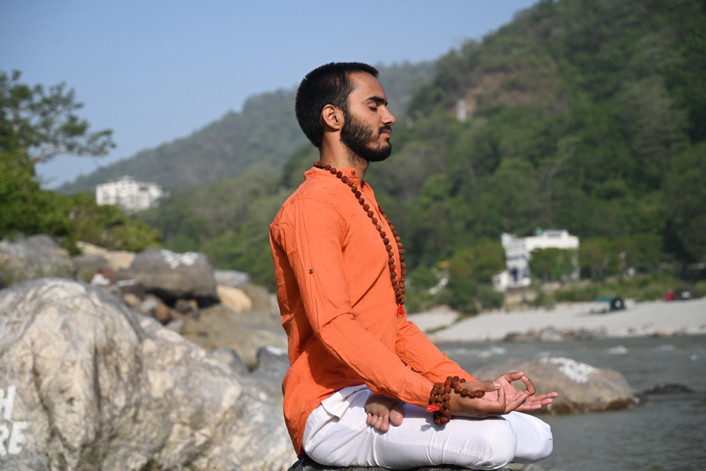 Sadhu meditating by the Ganges in Rishikesh, following the ancient yogic sadhana tradition