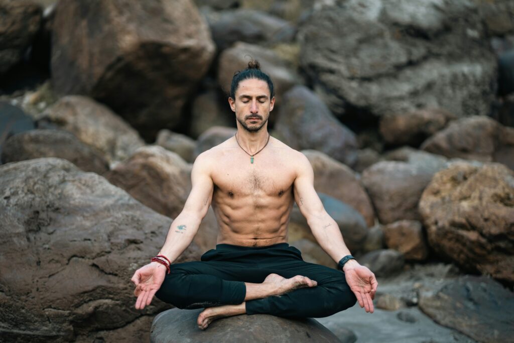 Person practicing seated meditation outdoors, representing mindfulness, breath awareness, and inner calm through yoga