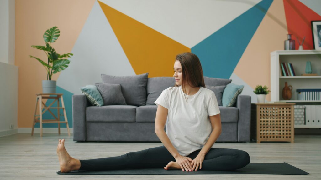 Person practicing gentle seated yoga at home as part of a calming routine to reduce stress and anxiety